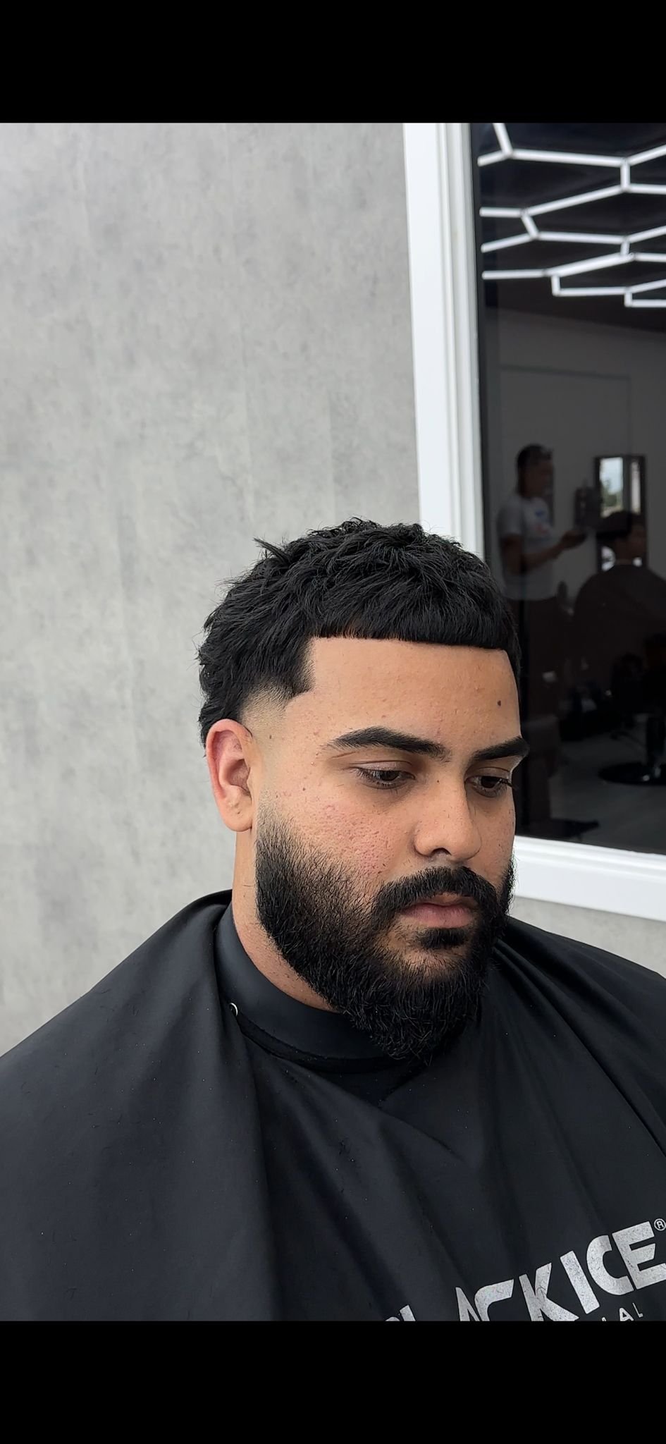 Curly hair fade with defined hairline and beard shaping.